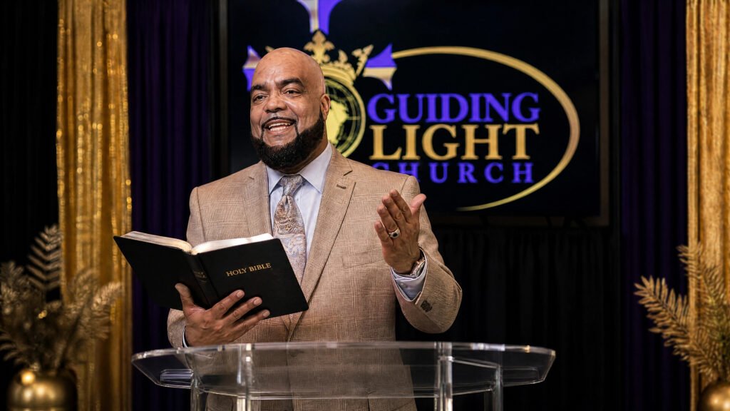 Pastor Eugene Moore preaching with an open Bible