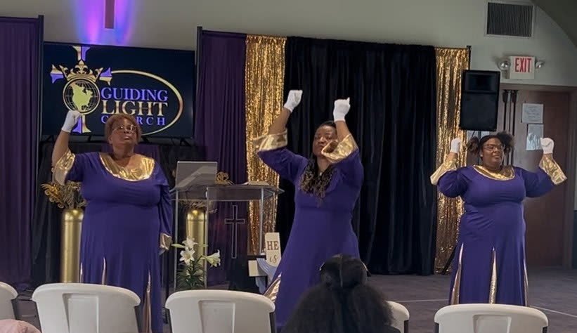 Praise dancers in purple and gold worshipping during service